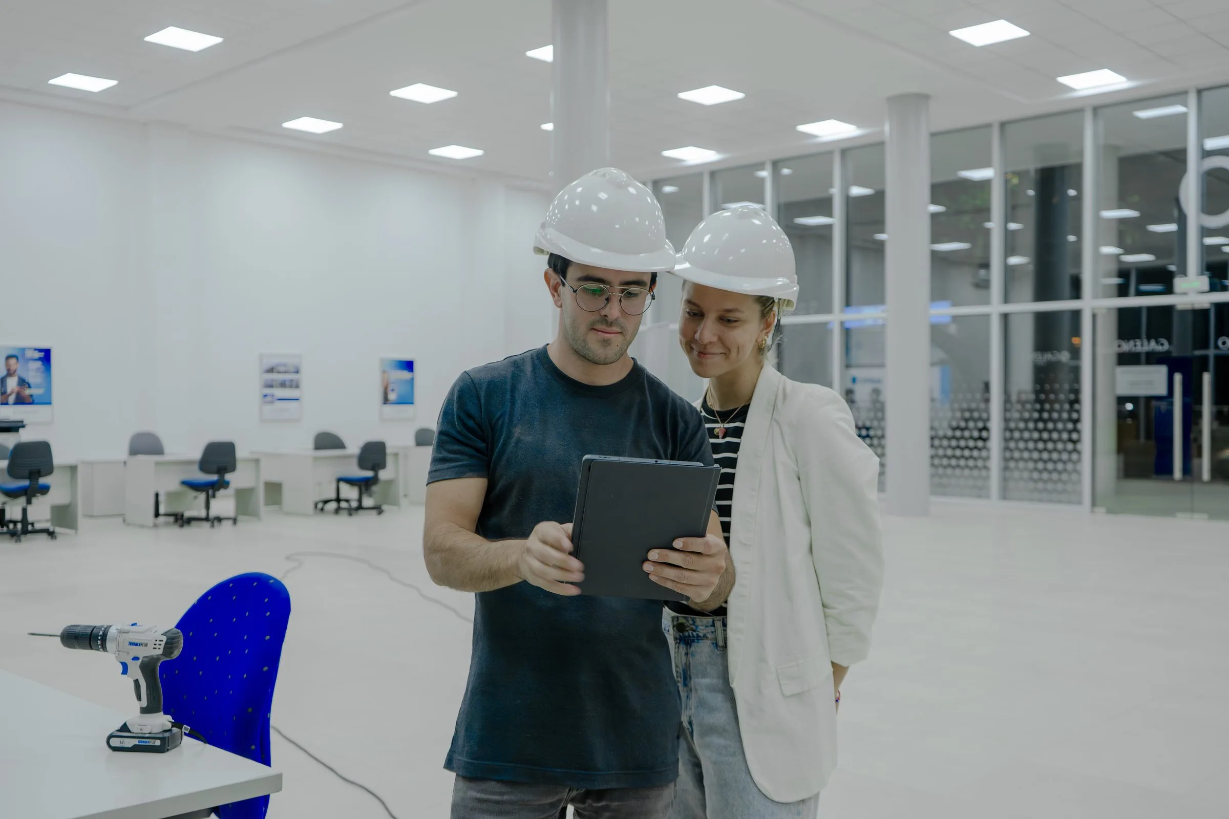 Equipo de Yunis Construcción revisando un proyecto en obra con tablet y casco