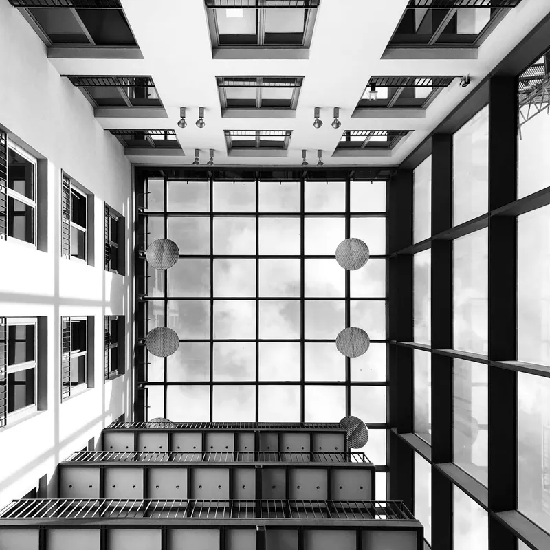 Vista cenital de un atrio arquitectónico con estructura de acero y vidrio